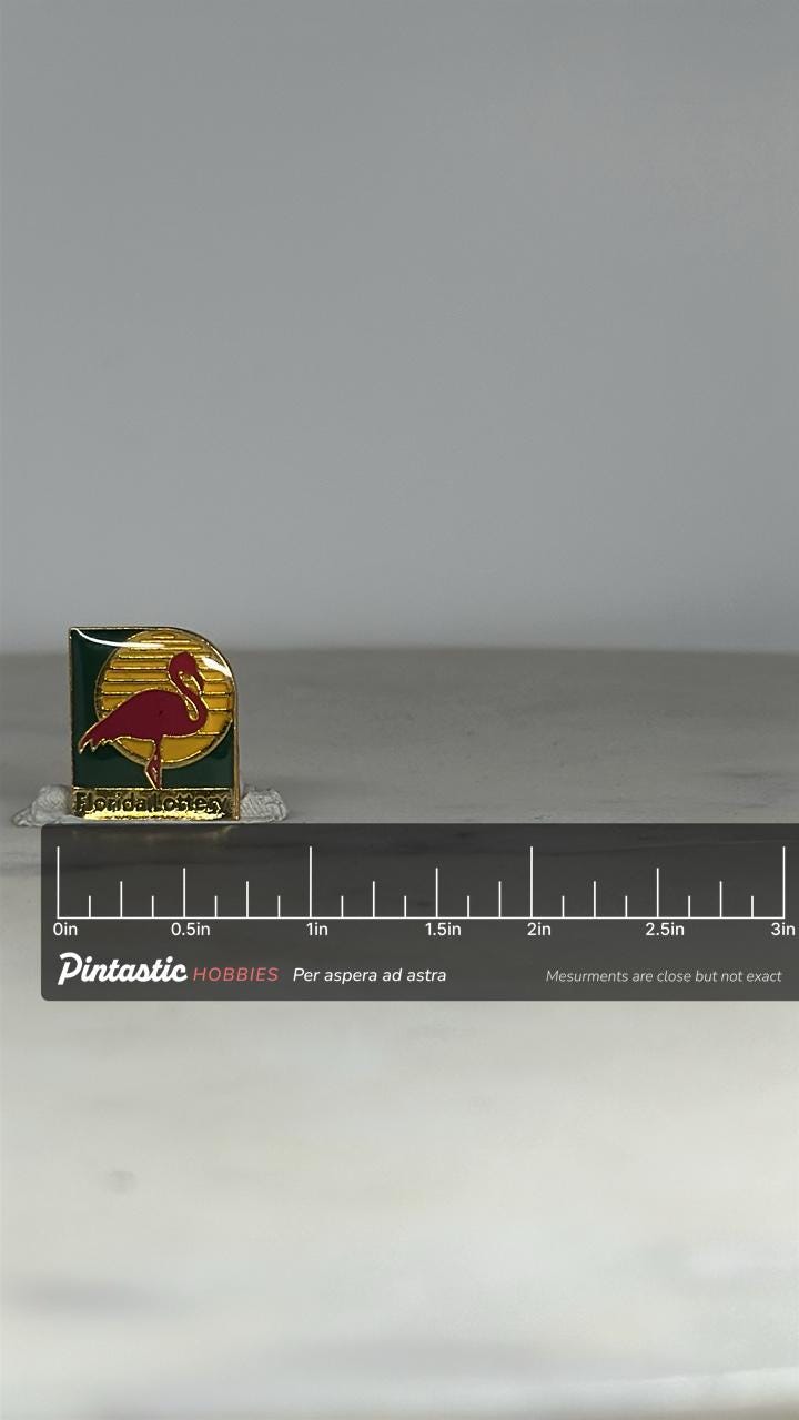 Florida Lottery Flamingo Pin: Gold & Enamel Finish - Retro Souvenir Accessory with ruler overlay for size reference