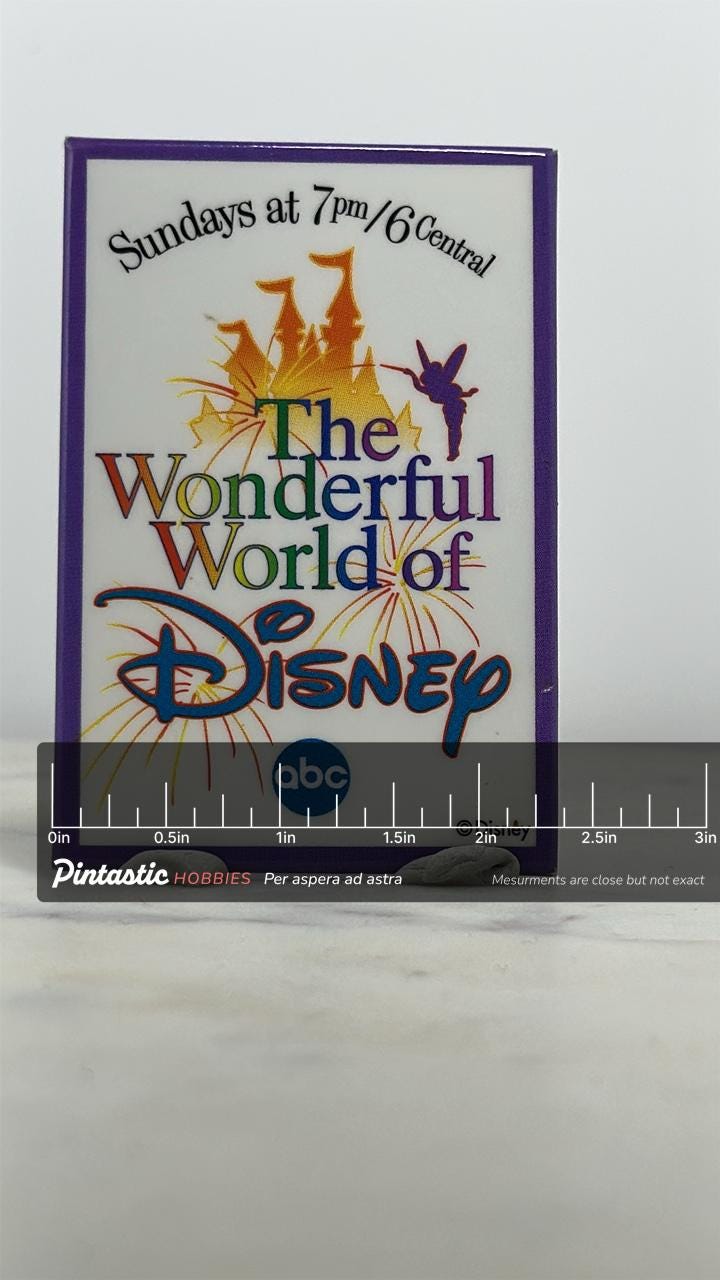 Wonderful World of Disney Enamel Pin: Purple Border Logo - 90s TV Accessory with ruler overlay for size reference
