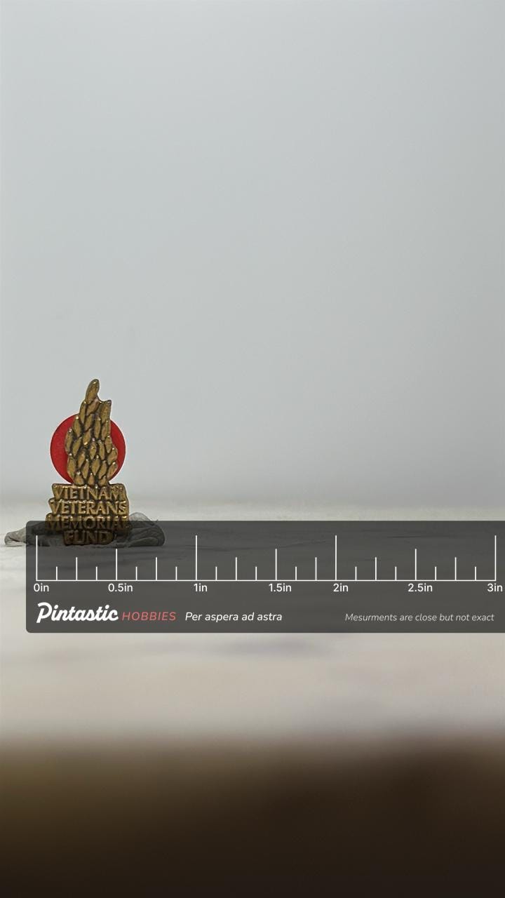 Vietnam Veterans Memorial Fund Pin: Bronze Red Flame - Military Tribute Accessory with ruler overlay for size reference