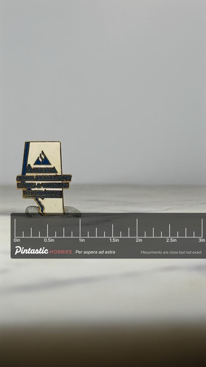 Alberta Foundation Enamel Pin: White & Blue Goldtone - Wildlife Org Accessory with ruler overlay for size reference
