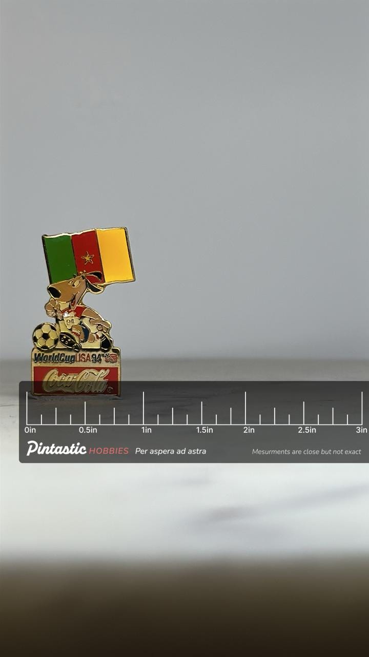 Cameroon World Cup Enamel Pin: Coca-Cola Mascot - 1994 Soccer Accessory with ruler overlay for size reference