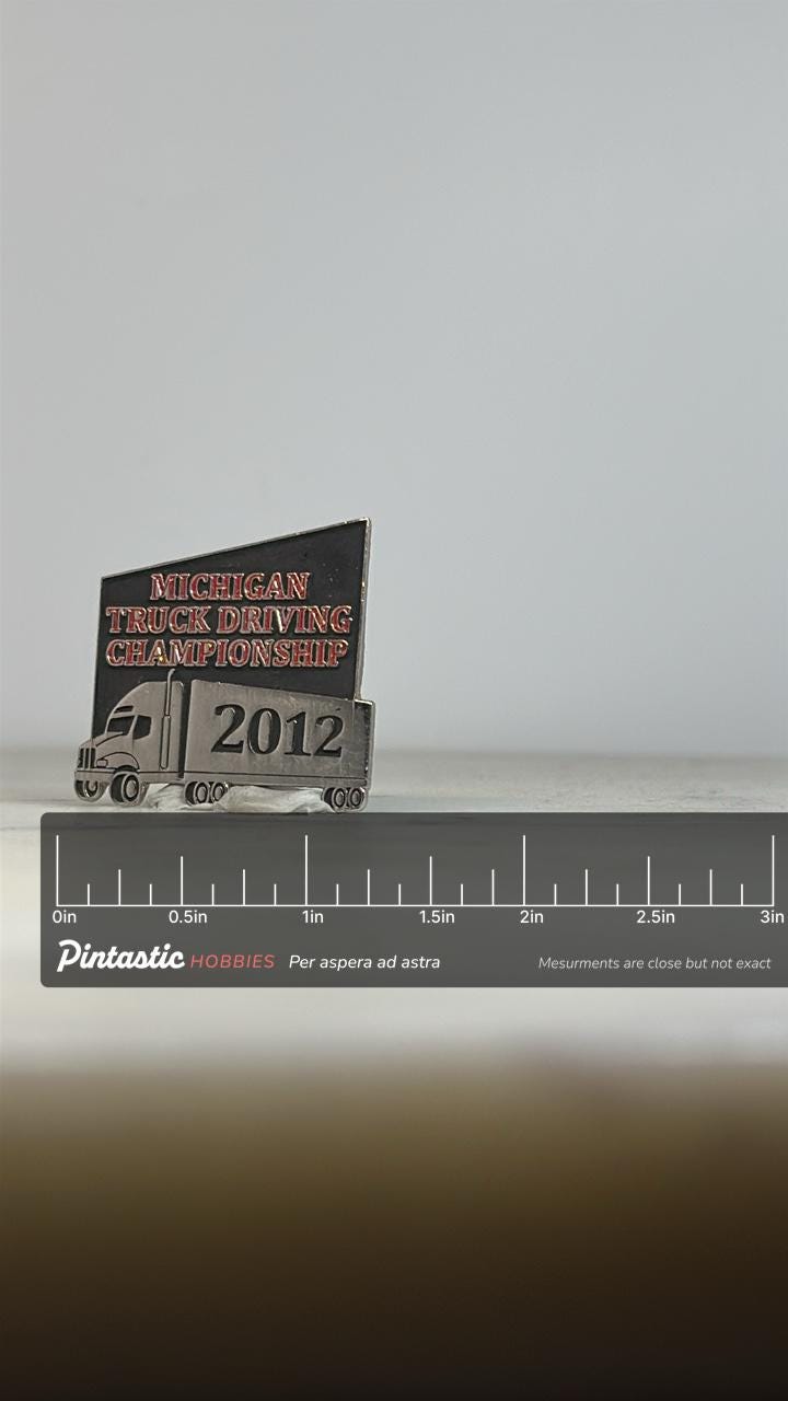 Michigan Truck Driving Championship Pin: Silver & Black Enamel - 2012 Event Accessory with ruler overlay for size reference