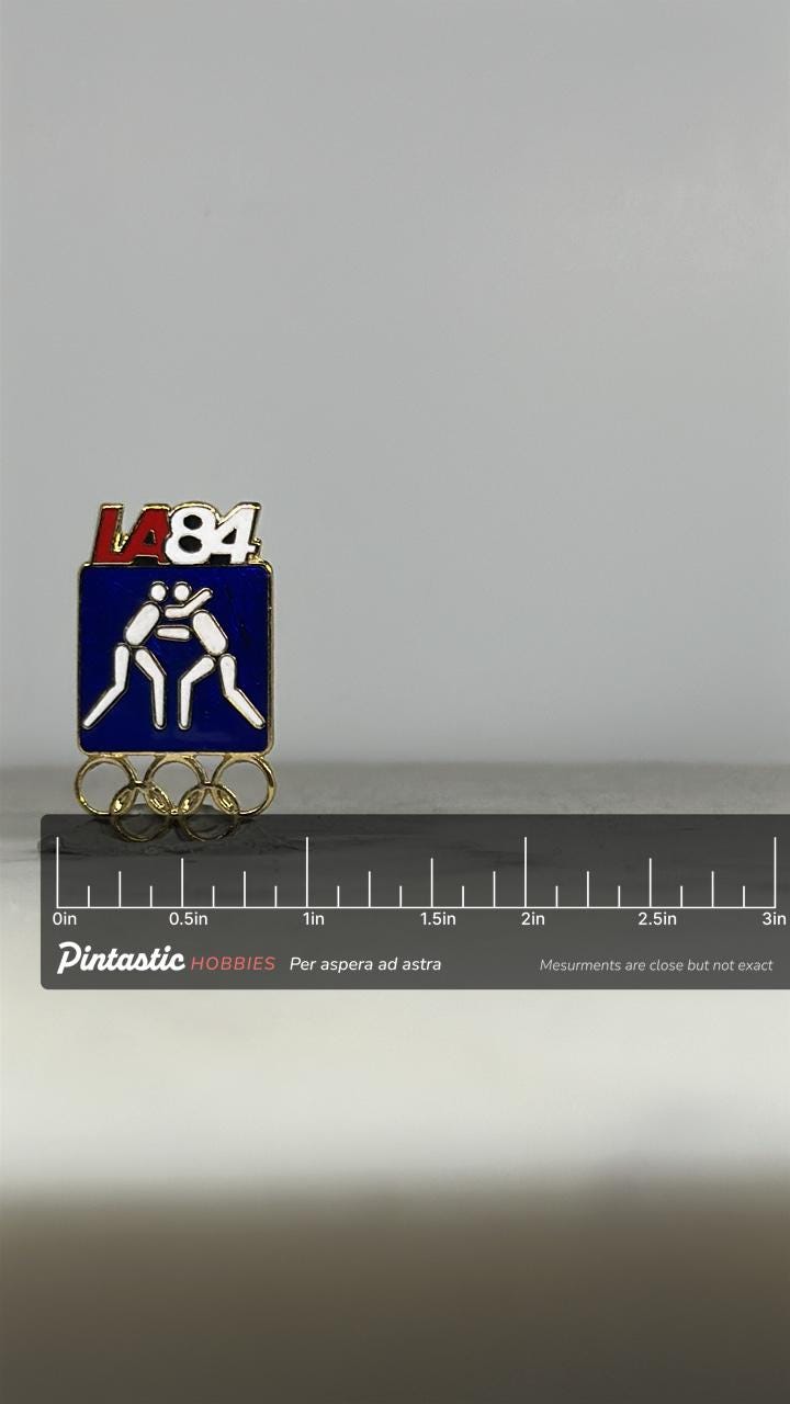 LA 84 Wrestling Olympic Pin: Blue Enamel & Gold Rings - Vintage Sports Accessory with ruler overlay for size reference