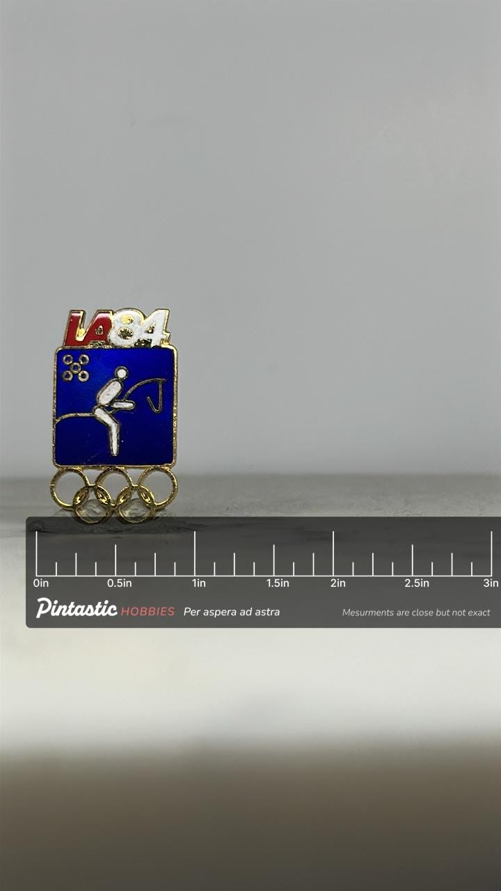 LA 1984 Pentathlon Olympic Pin: Blue Gold Enamel - Sports Accessory with ruler overlay for size reference