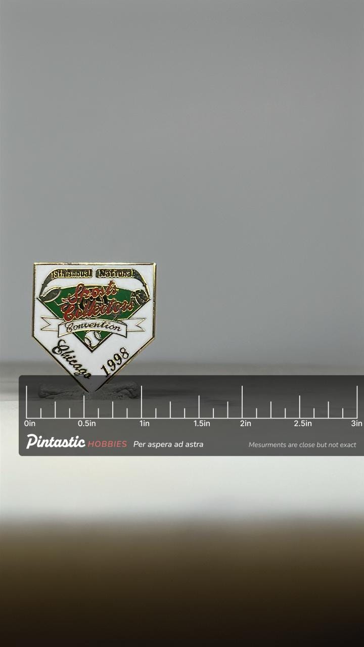 Sports Collectors Convention Pin: White Enamel Shield - 1998 Chicago Accessory with ruler overlay for size reference