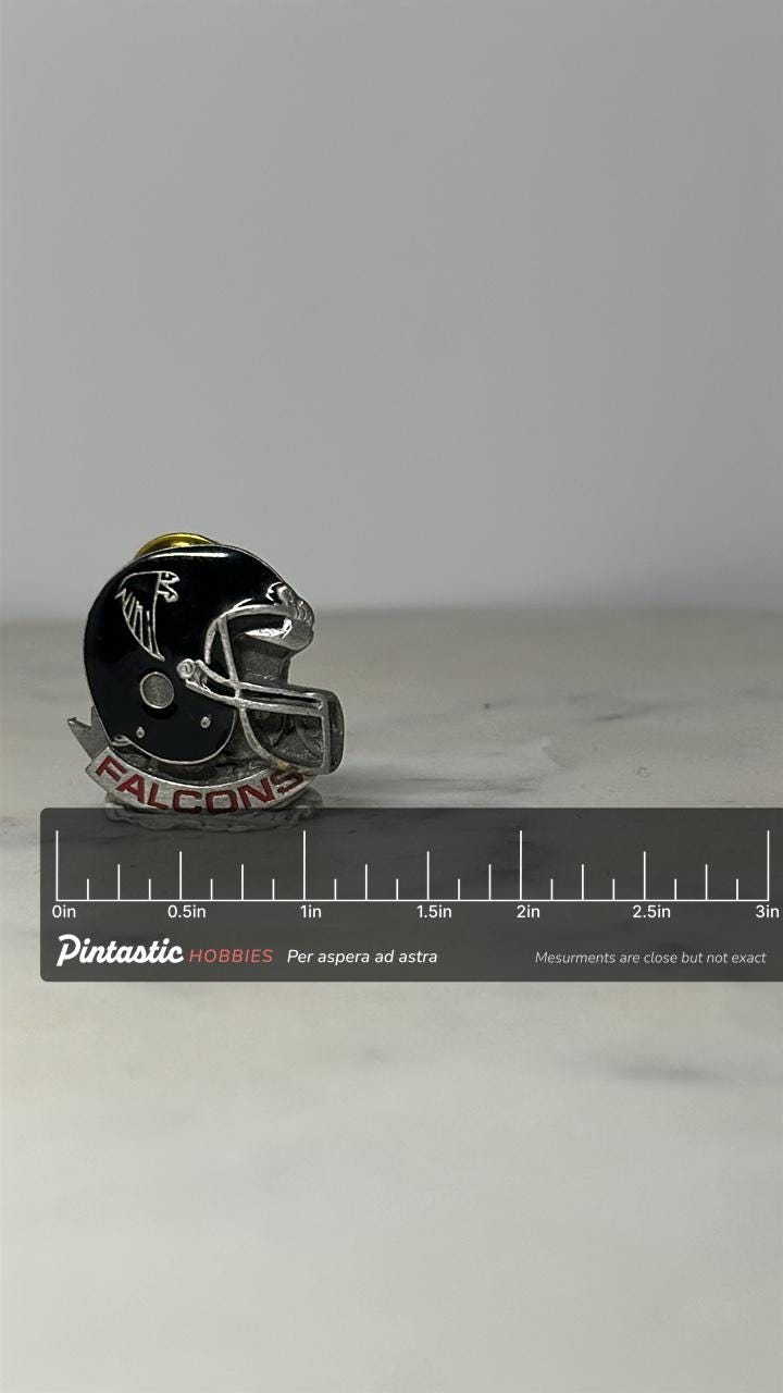 Atlanta Falcons Helmet Pin: Black & Silver Enamel - Vintage NFL Accessory with ruler overlay for size reference