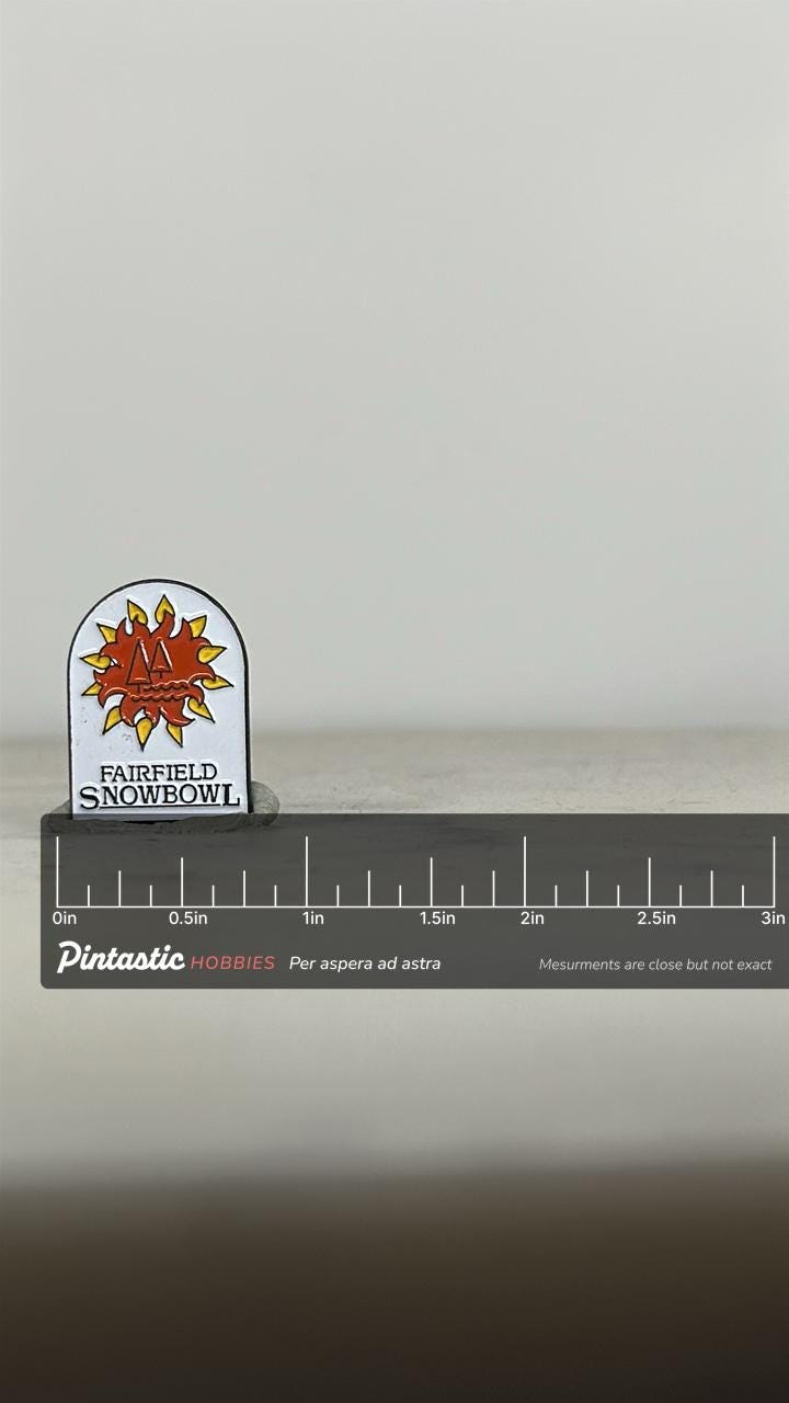 Fairfield Snowbowl Enamel Pin: Red & Yellow Sun Design - Vintage Ski Accessory with ruler overlay for size reference
