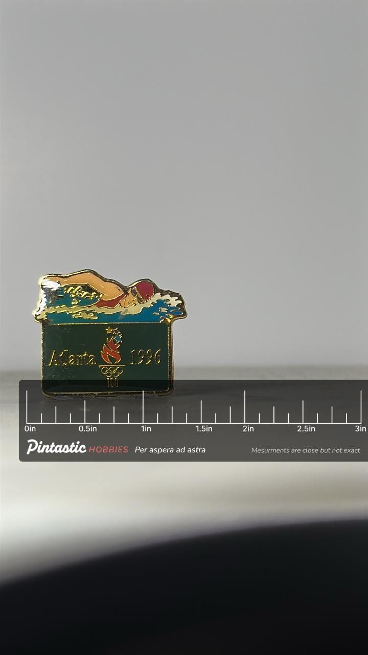 Atlanta Olympics Swimming Pin: Gold Enamel Finish - 1996 Sports Accessory with ruler overlay for size reference
