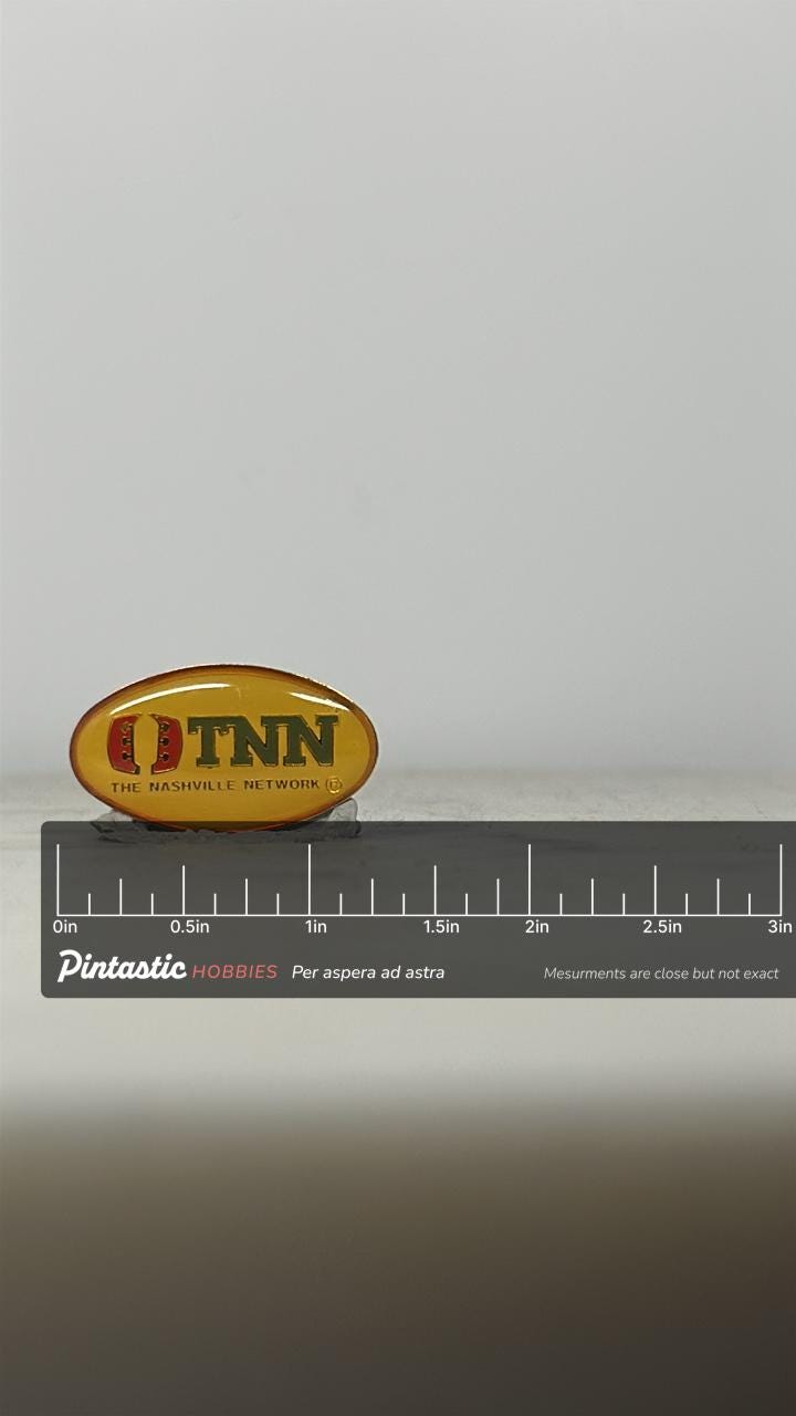 TNN Enamel Pin: Yellow Oval Logo - Vintage TV Accessory with ruler overlay for size reference