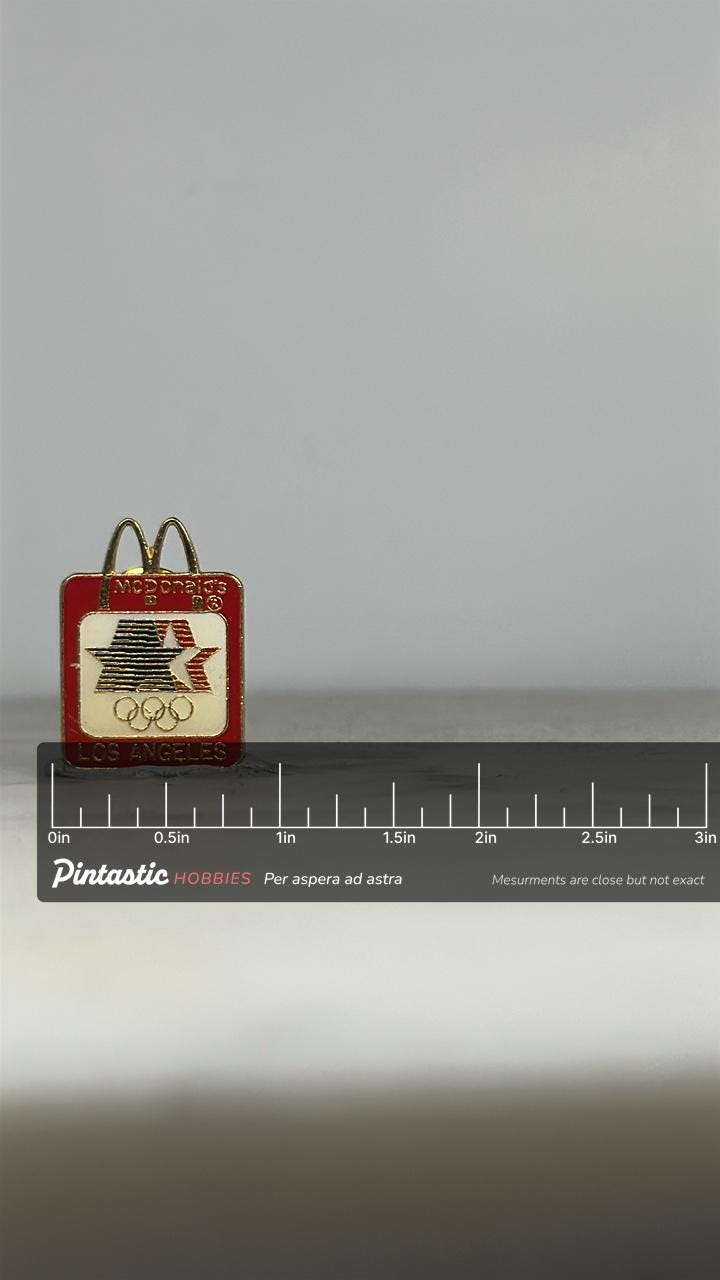 McDonald’s Olympic Pin: Red Gold Enamel - 1984 Los Angeles Collectible with ruler overlay for size reference