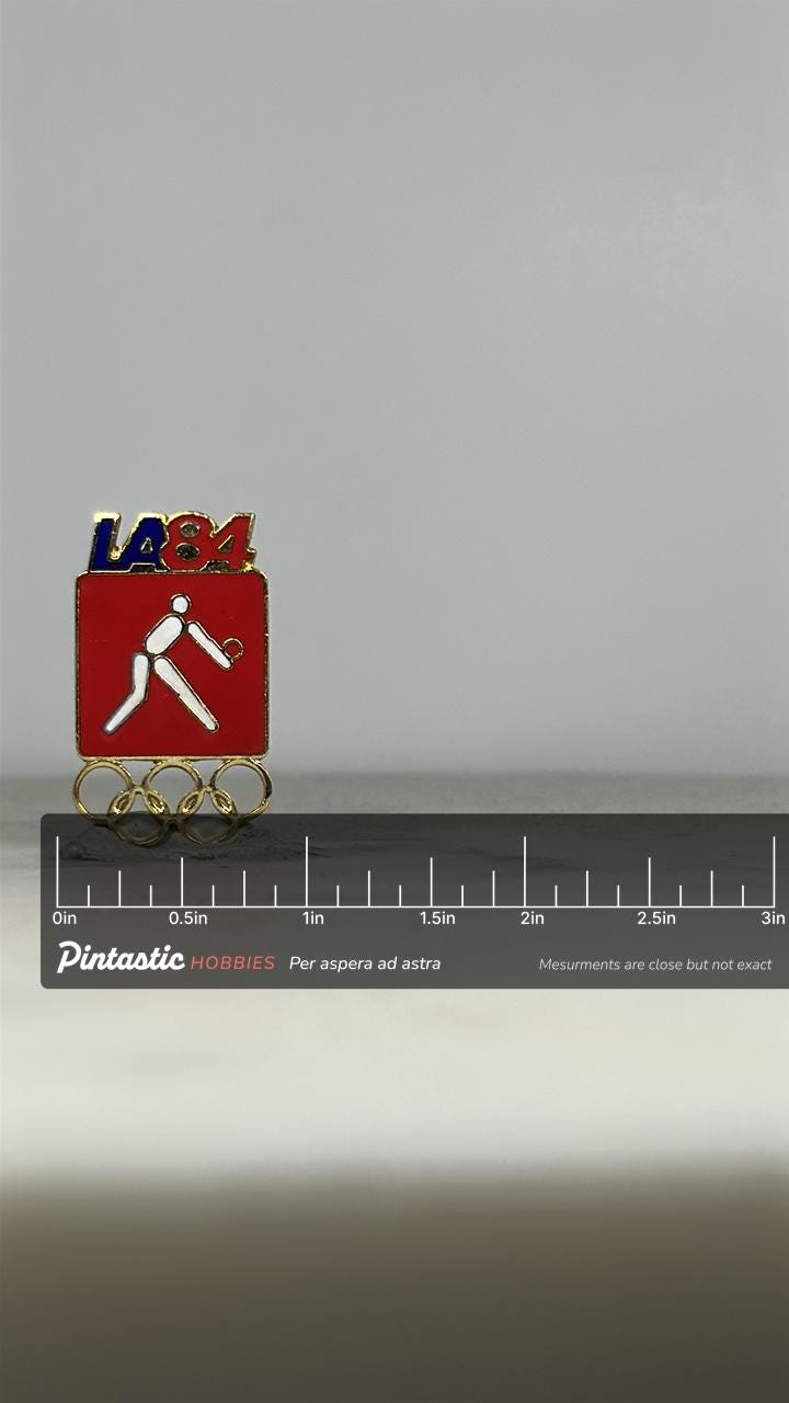 LA84 Olympics Volleyball Pin: Red Enamel & Gold - 1984 Sports Accessory with ruler overlay for size reference