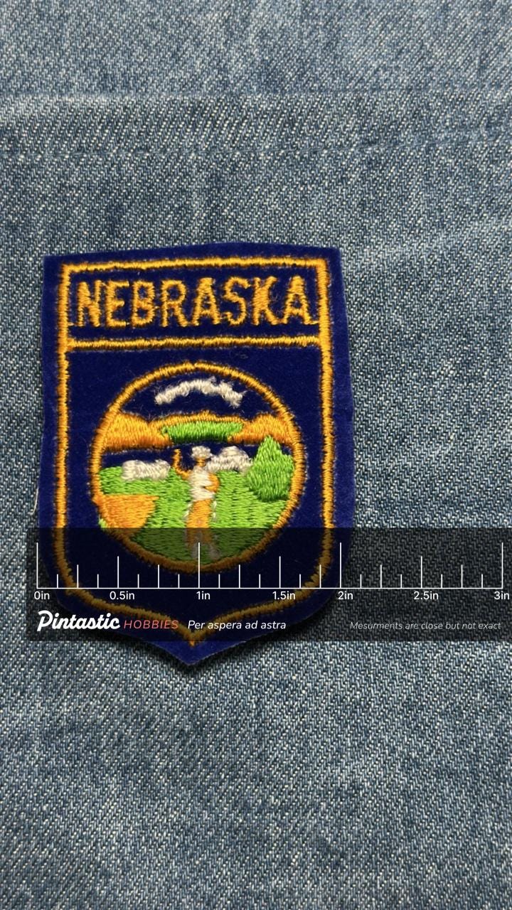 Nebraska Sew-On Patch: Blue and Gold - Vintage State Souvenir Accessory with ruler overlay for size reference