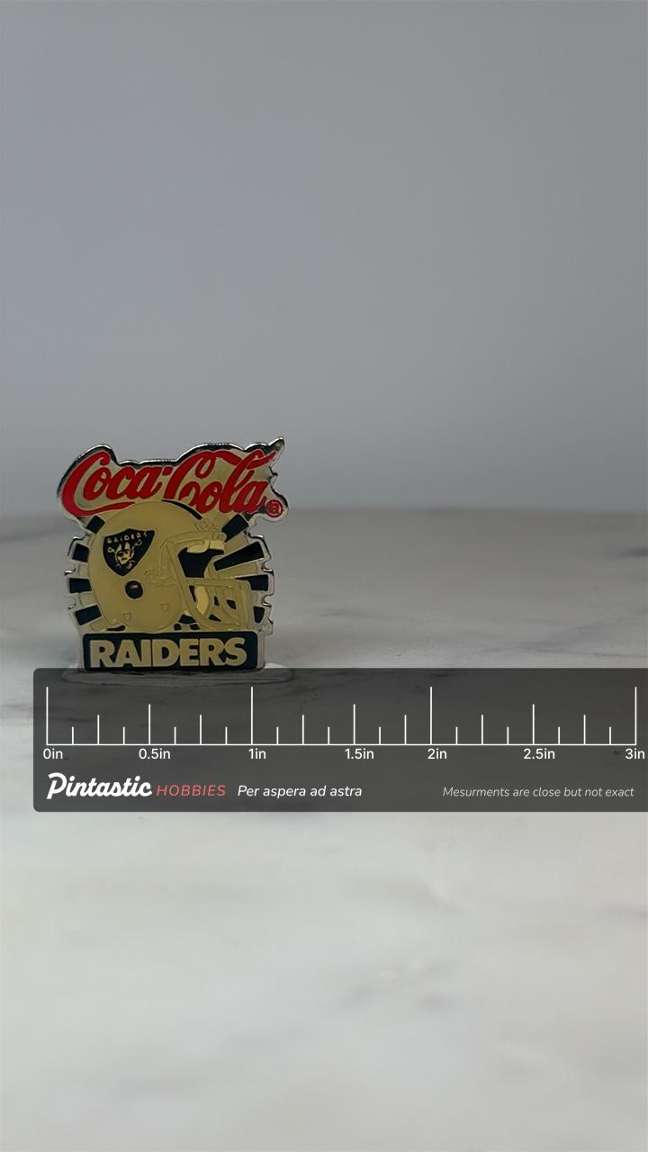 Coca-Cola Raiders Pin: Gold & Black Enamel - Vintage Sports Accessory with ruler overlay for size reference
