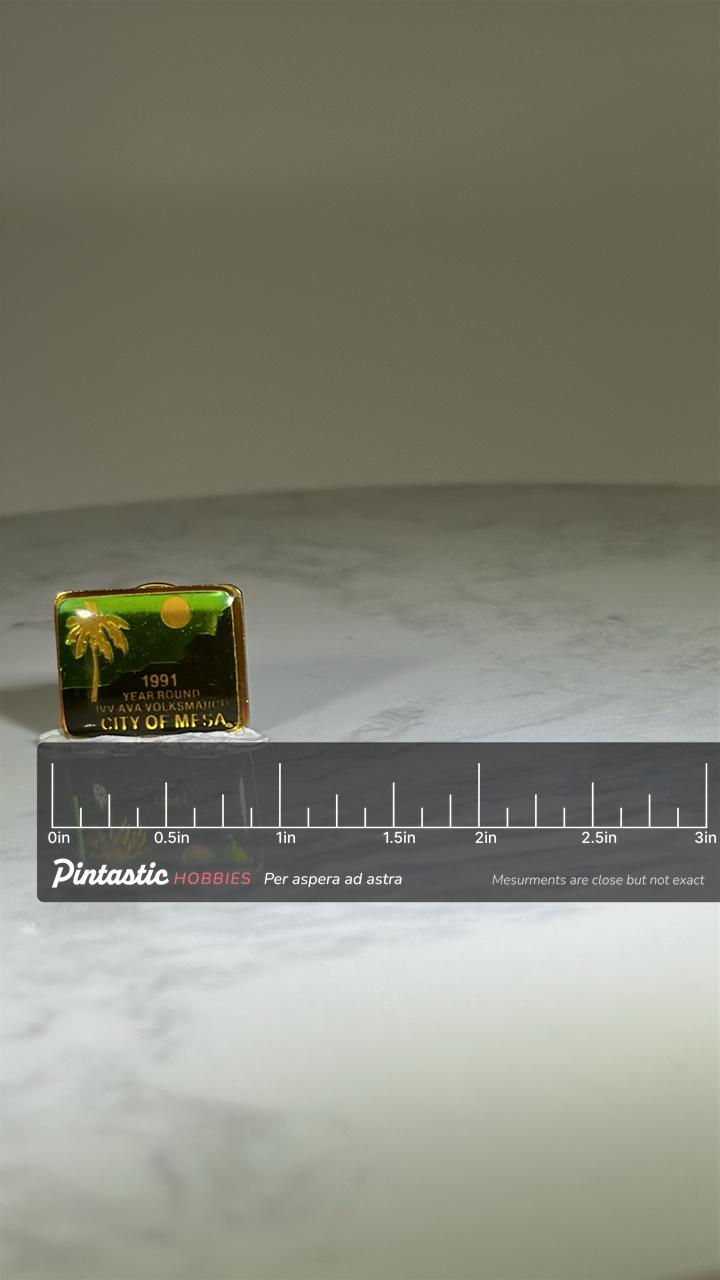 City of Mesa 1991 Volksmarch Pin: Green Gold Finish - Desert Sunset Souvenir with ruler overlay for size reference
