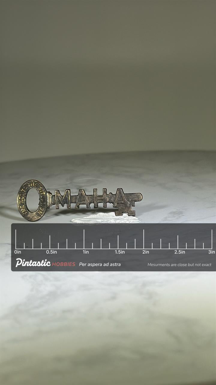 Omaha Key Shaped Pin: Antiqued Brass Finish - Mid-Century Souvenir Accessory with ruler overlay for size reference