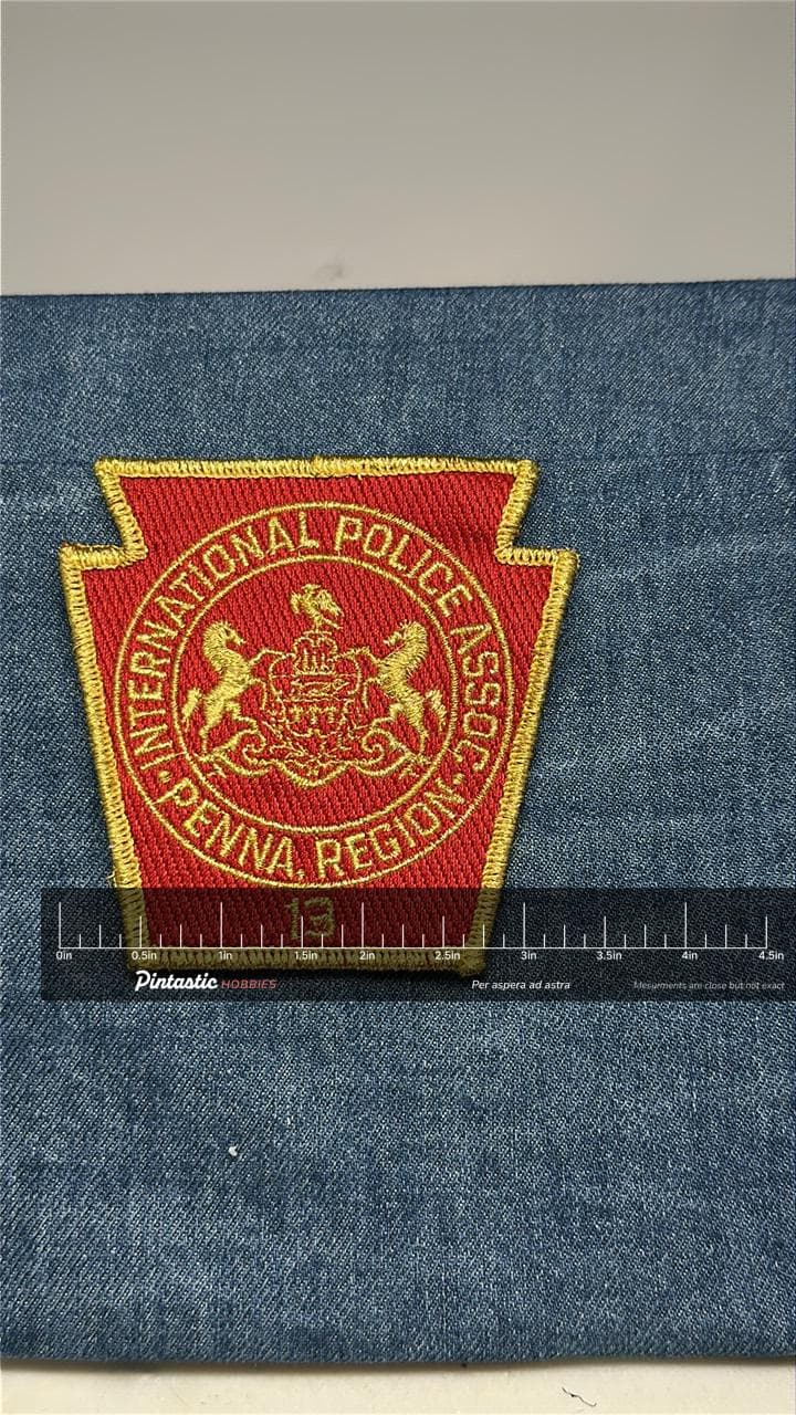 International Police Assoc Collectable Patch: Sew-On Red Gold - Law Enforcement Accessory with ruler overlay for size referen