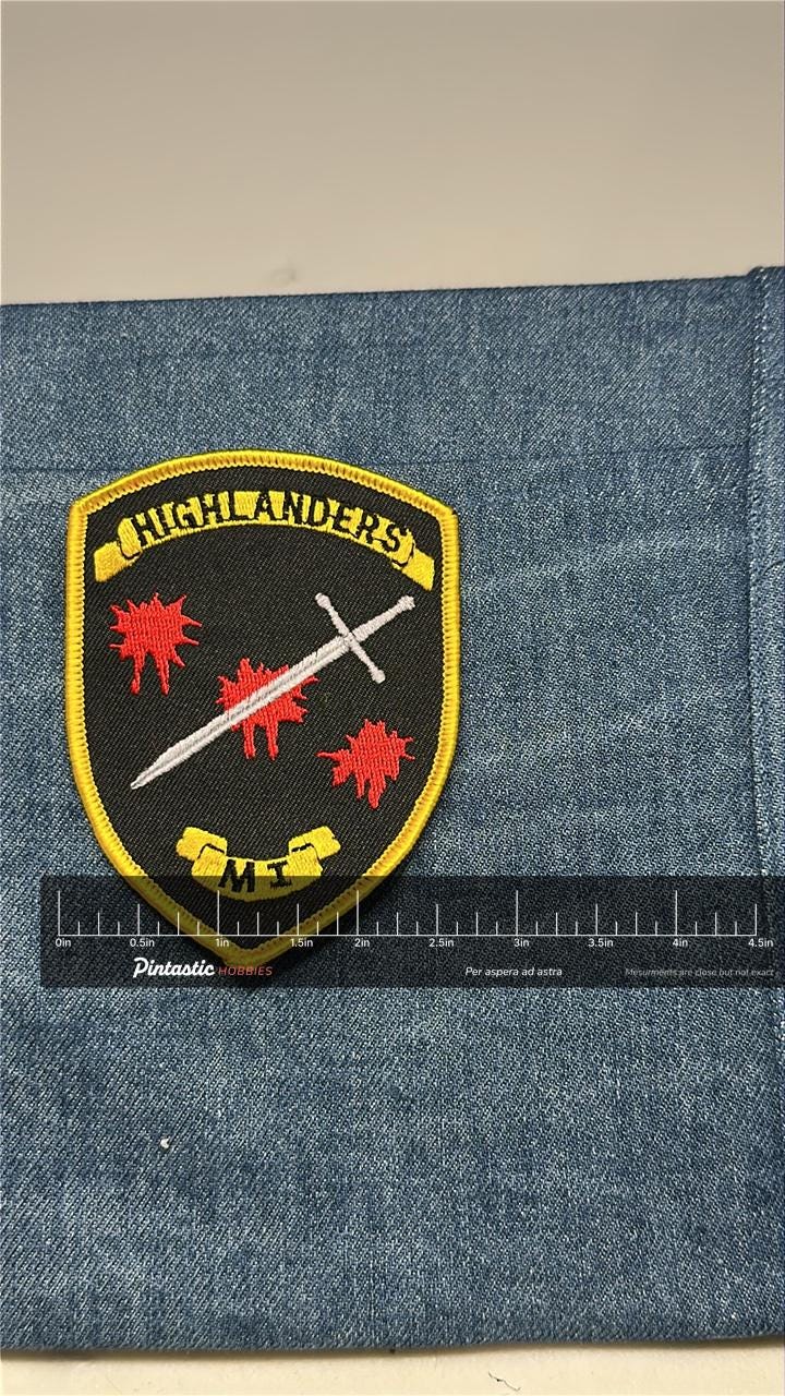 Highlanders ME Paintball Patch: Sew-On Black/Yellow Shield - Military Accessory with ruler overlay for size reference