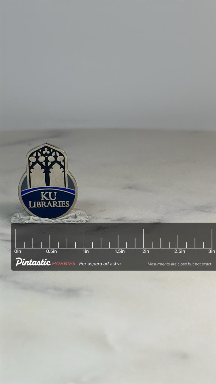 KU Libraries Collectible Pin: Silver & Blue Enamel - Academic Accessory with ruler overlay for size reference