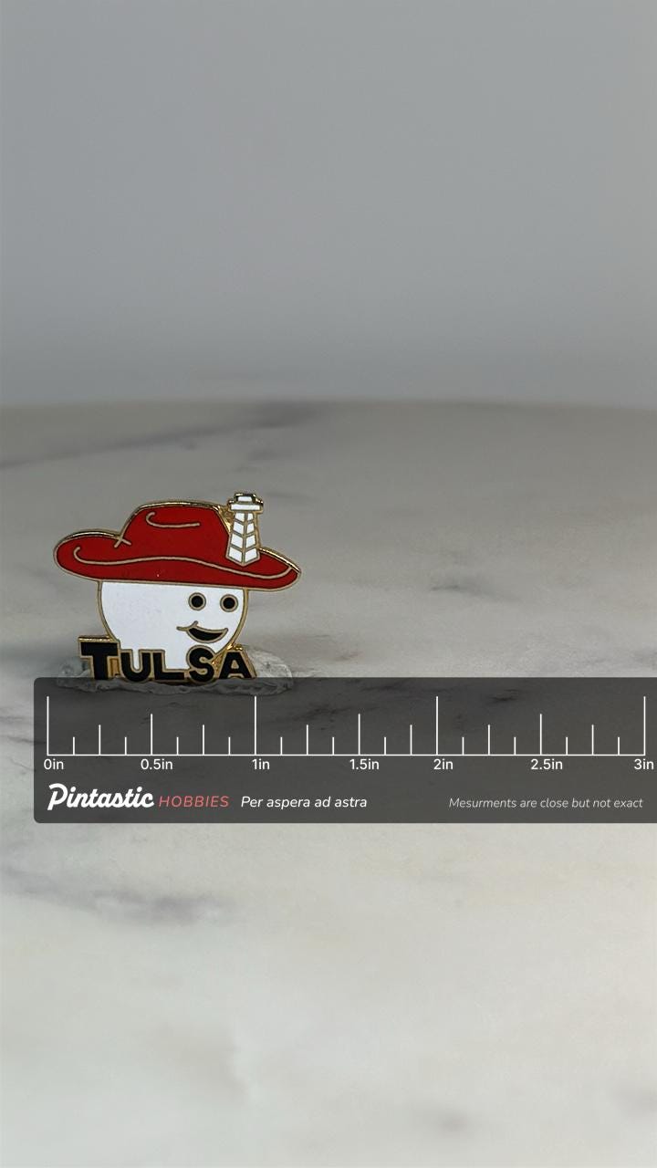 Tulsa Souvenir Pin: Red Hat Smiley Design - Vintage Travel Accessory with ruler overlay for size reference