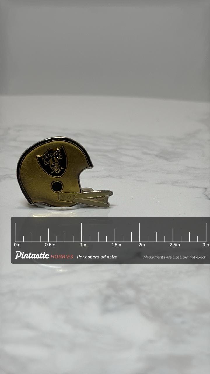 Raiders Football Helmet Pin: Vintage Gold Tone - Sports Fan Accessory with ruler overlay for size reference