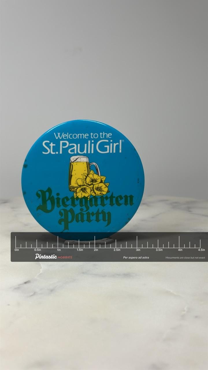 St Pauli Girl Beer Pin: Blue Metal Button - Biergarten Party with ruler overlay for size reference