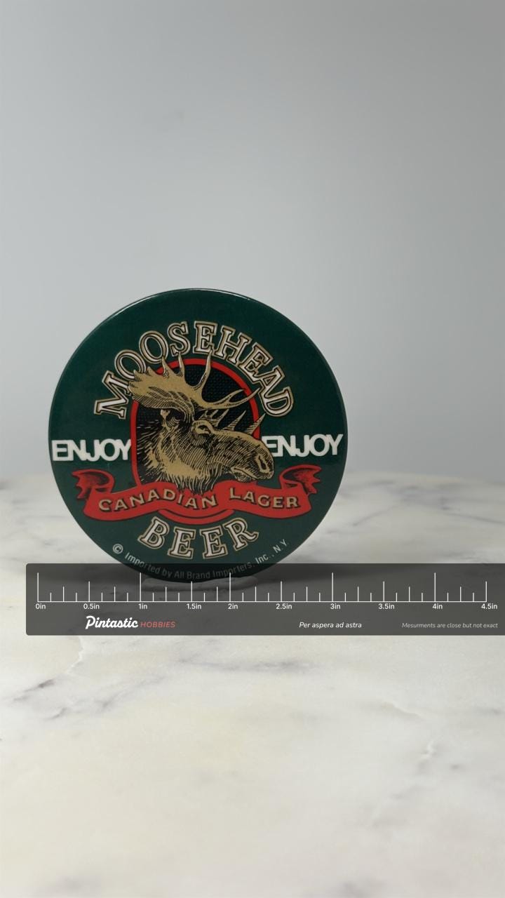 Moosehead Beer Button Pin: Green Enamel - Canadian Lager Accessory with ruler overlay for size reference