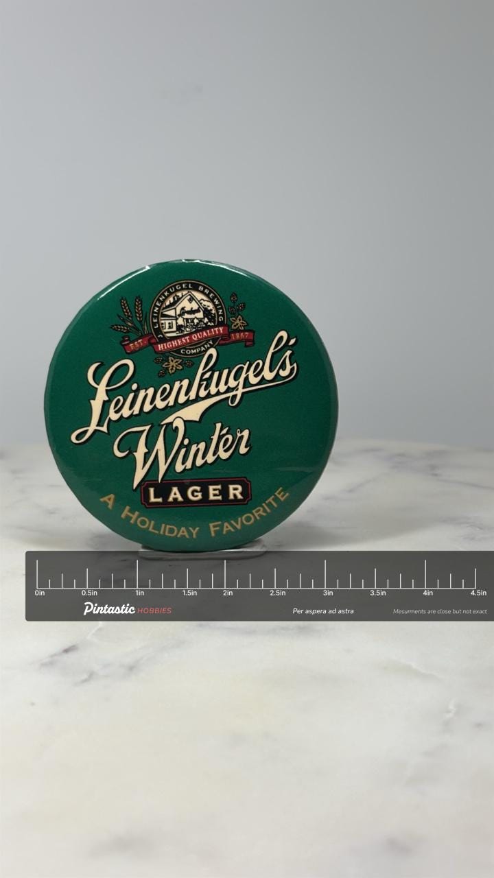 Leinenkugels Winter Lager Beer Button Pin: Green Logo - Holiday Promo Accessory with ruler overlay for size reference