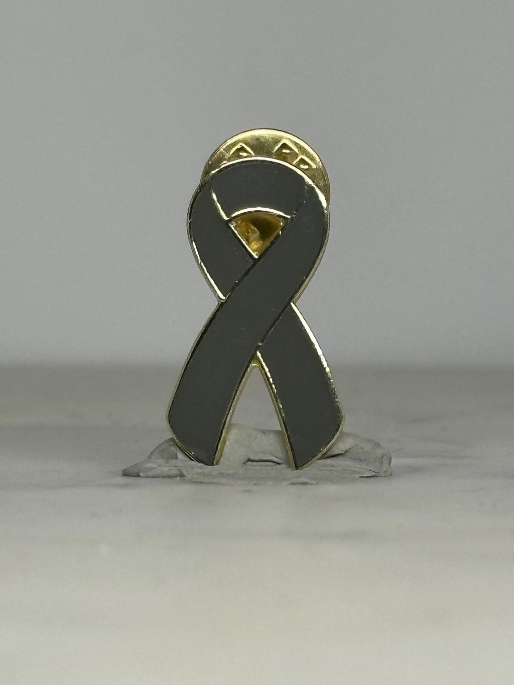 Gray awareness ribbon enamel pin: gold trim finish - supportive cause accessory