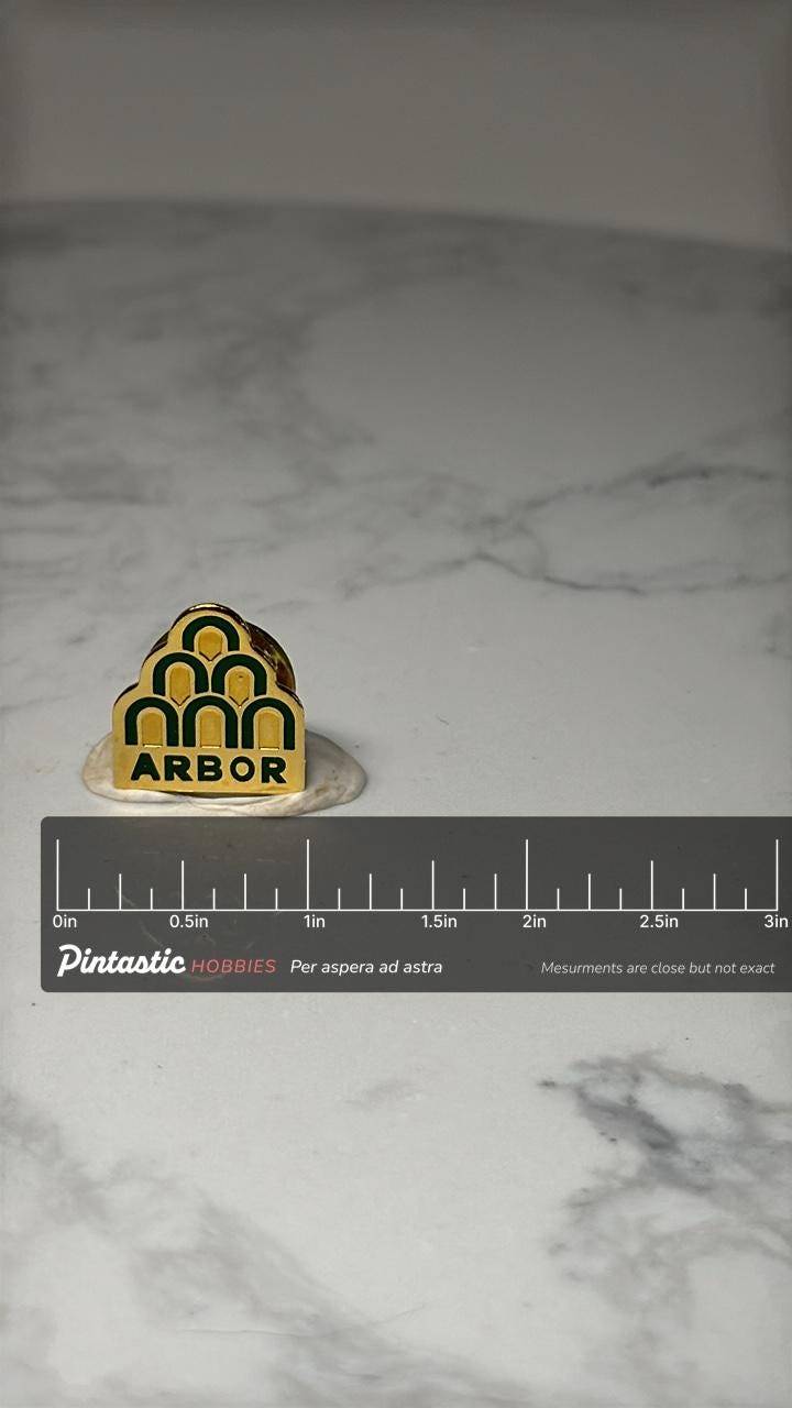 Arbor Drugs Logo Pin: Green & Yellow Enamel - 1990s Company Accessory with ruler overlay for size reference