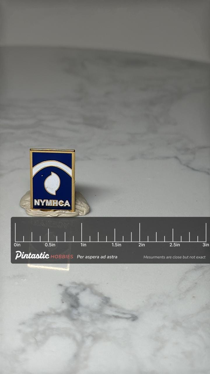NYMHCA Enamel Lapel Pin: Blue & Gold - Mental Health Association with ruler overlay for size reference