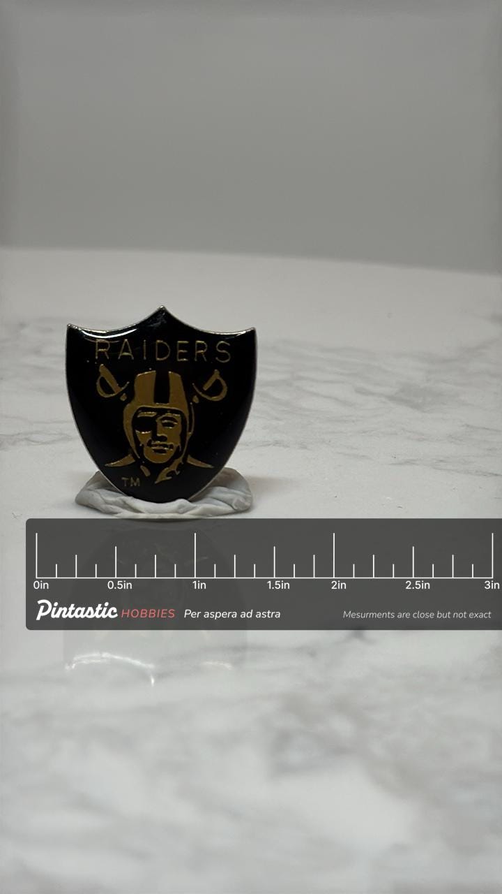 Raiders NFL Team Pin: Black & Gold Enamel - Vintage Sports Accessory with ruler overlay for size reference