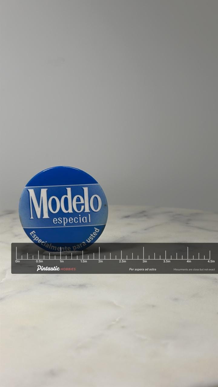 Modelo Especial Beer Button Pin: Blue Logo - Breweriana Accessory with ruler overlay for size reference