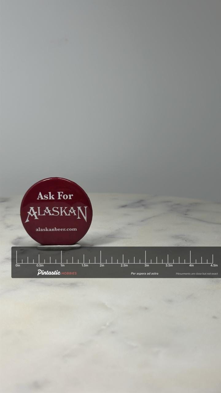 Alaskan Brewing Advertising Button Pin: Red White - Beer Promo Accessory with ruler overlay for size reference