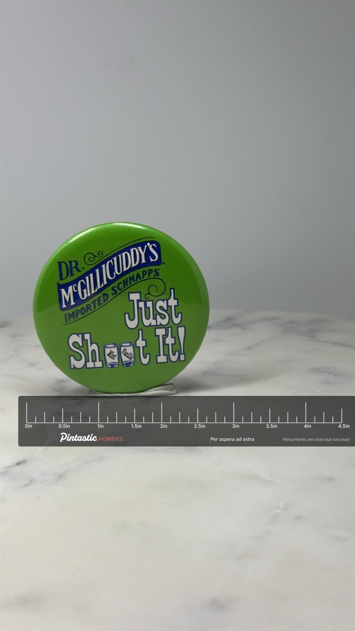 Dr McGillicuddys Schnapps Button Pin: Green Promo - Bar Advertising with ruler overlay for size reference