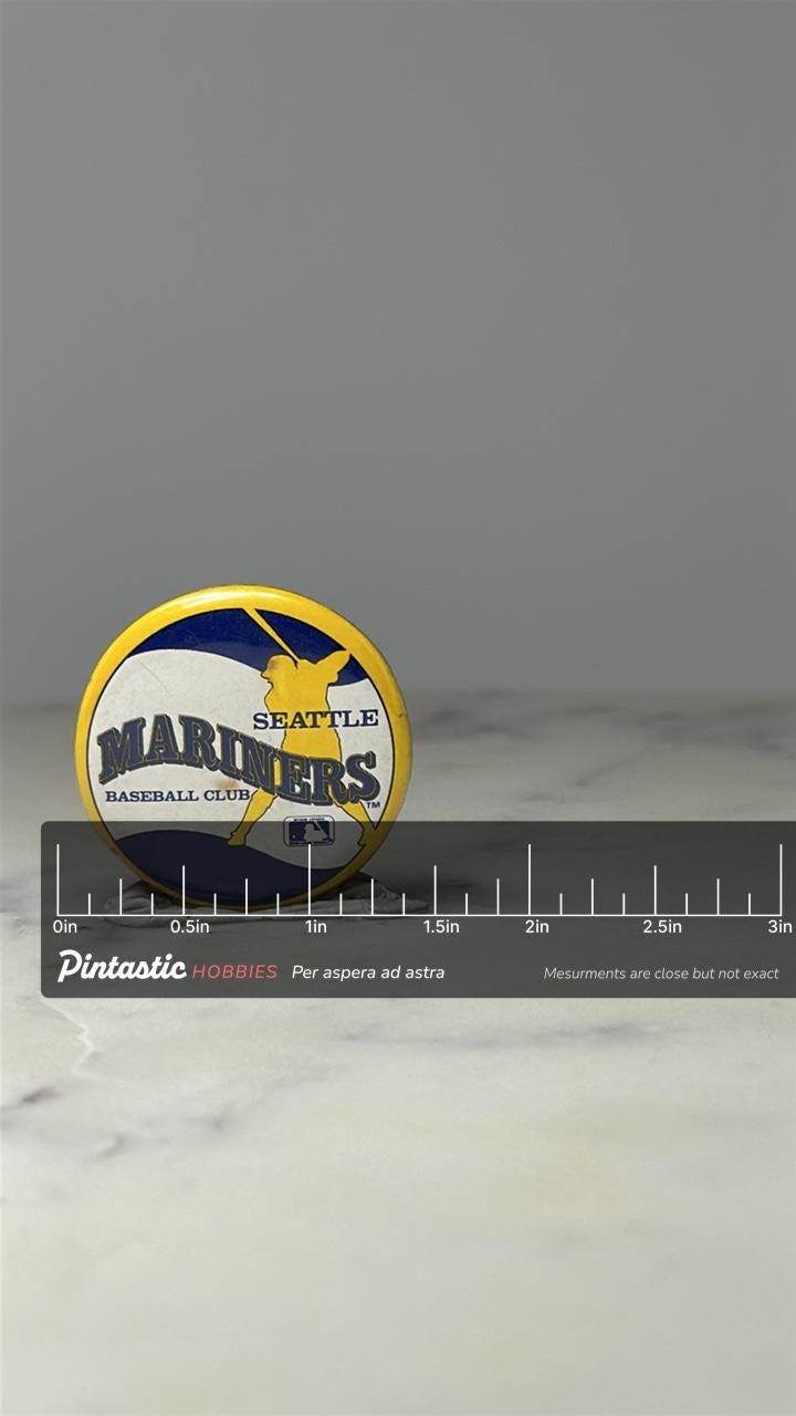 Seattle Mariners Baseball Pin: Blue Yellow Enamel - MLB Era with ruler overlay for size reference