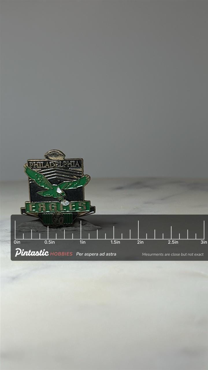 Philadelphia Eagles Football Pin: Green Enamel - NFL Sports Accessory with ruler overlay for size reference