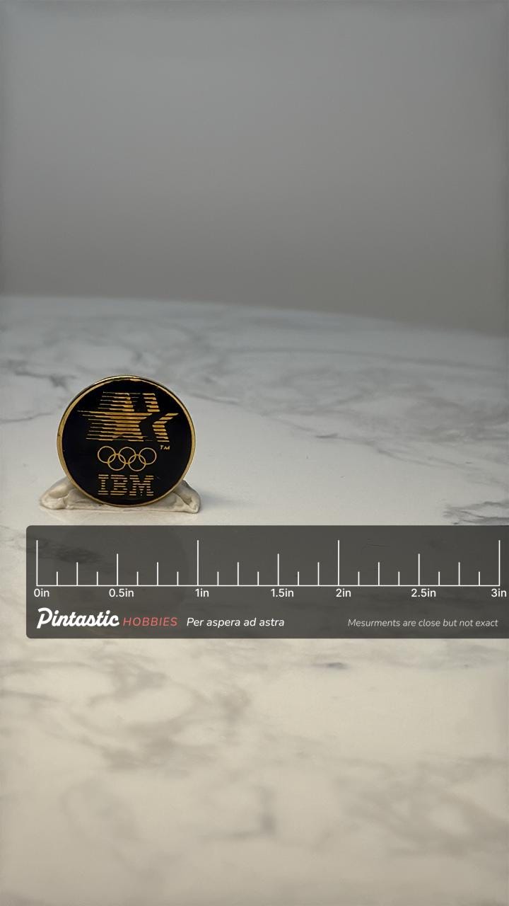 Vintage IBM Olympic Sponsor Lapel Pin: Black & Gold Enamel - 1980s Corporate Accessory with ruler overlay for size reference
