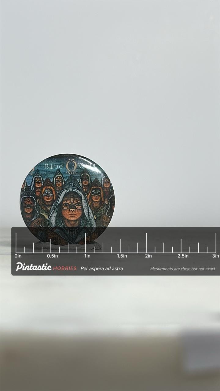 Blue öyster cult button pin: album art badge - retro rock accessory with ruler overlay for size reference