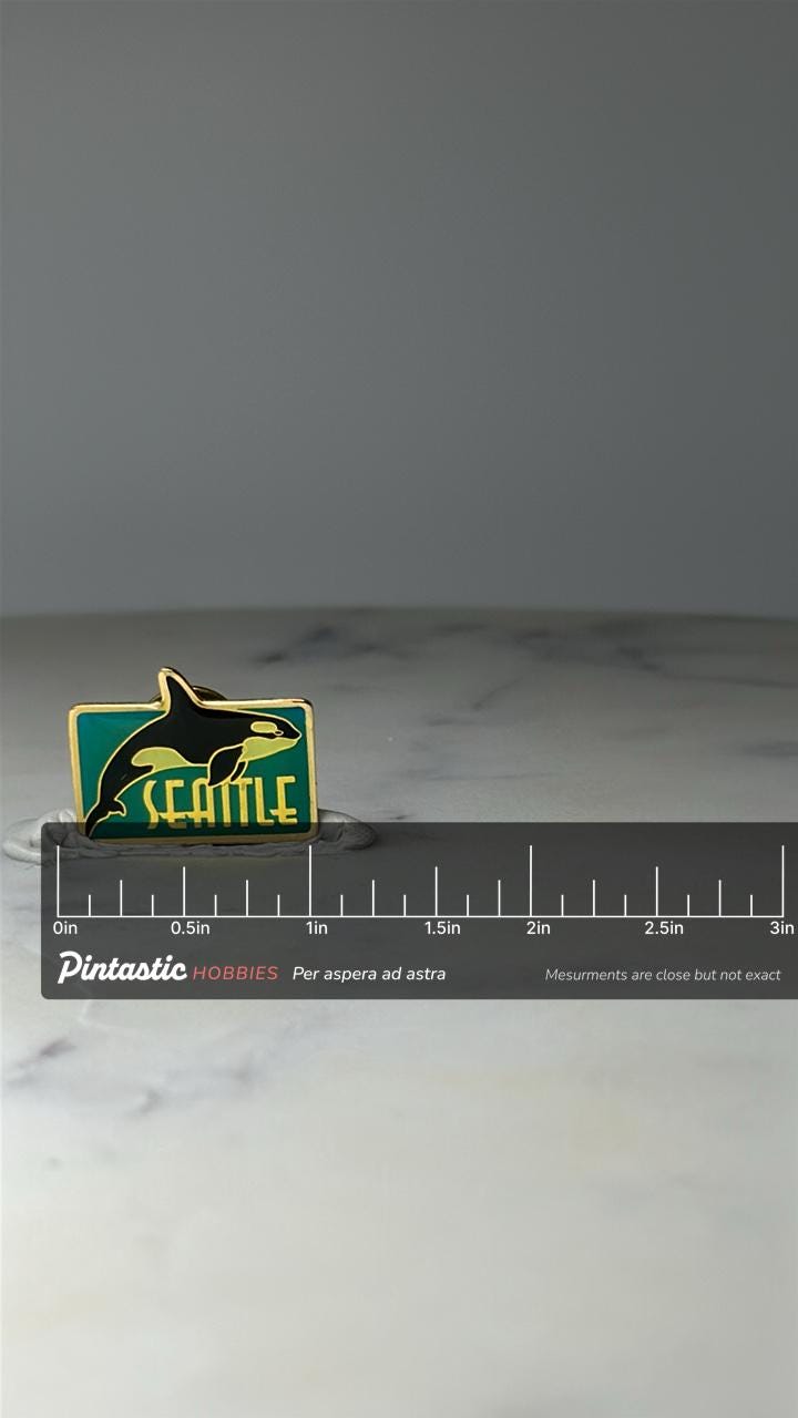 Vintage Seattle Orca Enamel Pin: Green & Gold - PNW Souvenir Accessory with ruler overlay for size reference