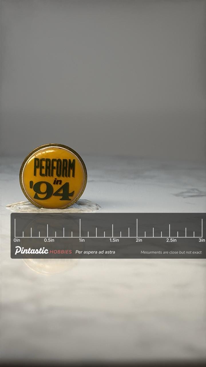 Vintage Perform in 94 Slogan Pin: Yellow Black - 1994 Sales Theme Accessory with ruler overlay for size reference