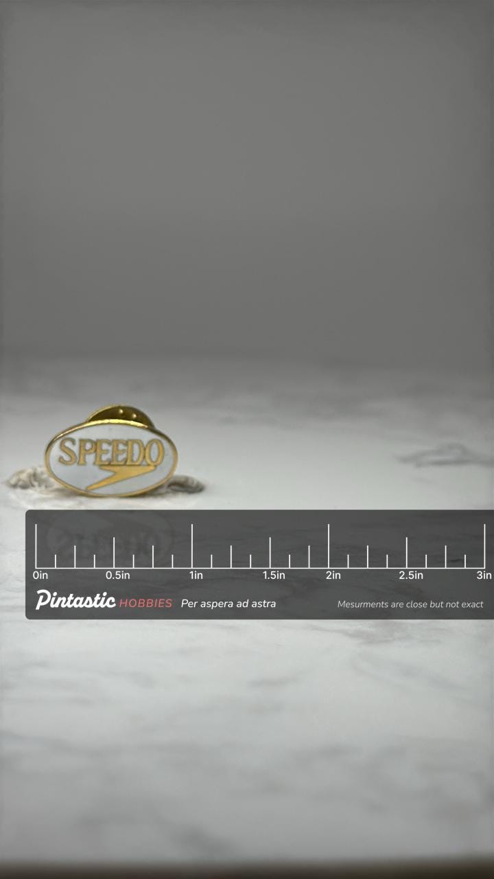 Speedo Logo Lapel Pin: Gold Tone Enamel - Swim Brand Accessory with ruler overlay for size reference