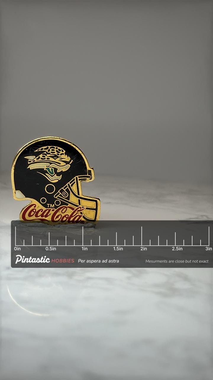 Jacksonville Jaguars Helmet Pin: Gold Tone Enamel - NFL Coca Cola with ruler overlay for size reference