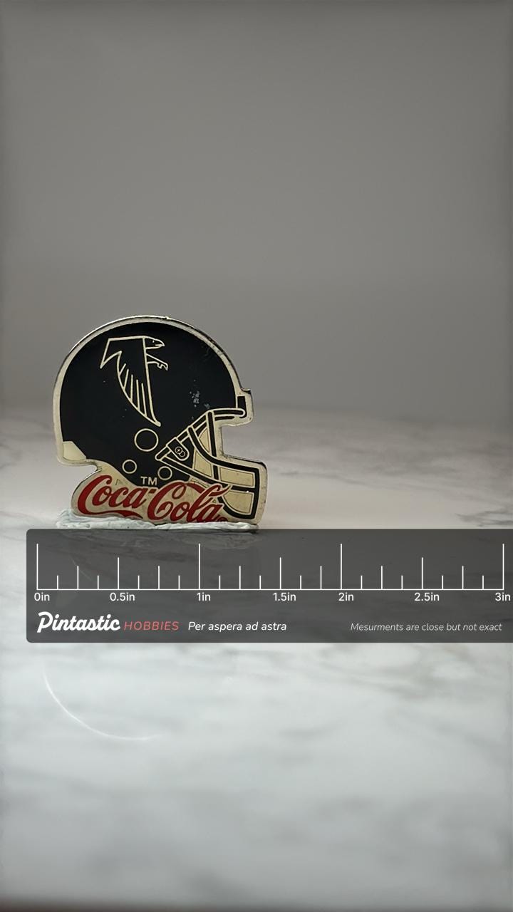 Atlanta Falcons Helmet Pin: Black Enamel - Coca Cola Promo with ruler overlay for size reference
