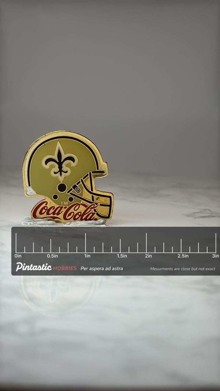 New Orleans Saints Helmet Pin: Gold Enamel - Coca Cola Promo with ruler overlay for size reference