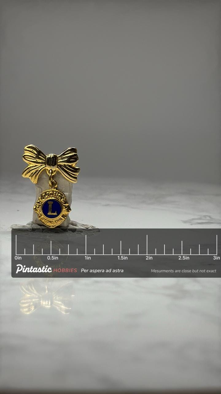 Lions Club Dangle Pin: Gold Tone Bow - Fraternal Accessory with ruler overlay for size reference